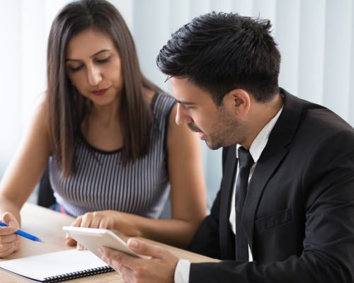 Serious busy young business colleagues discussing agenda. Thoughtful modern business team sitting at table and analyzing information. Teamwork